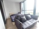 Bedroom with black leather sofa and glass wall