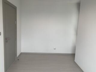 Empty room with closed door and walls painted white