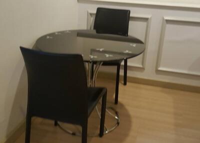 Small dining area with two black chairs and a round table