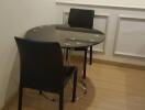 Small dining area with two black chairs and a round table