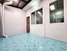 Room with blue patterned floor tiles and glass windows