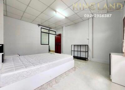 Spacious bedroom with white tiled flooring and a large bed