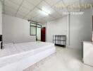 Spacious bedroom with white tiled flooring and a large bed