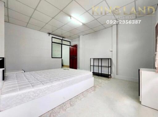 Spacious bedroom with white tiled flooring and a large bed