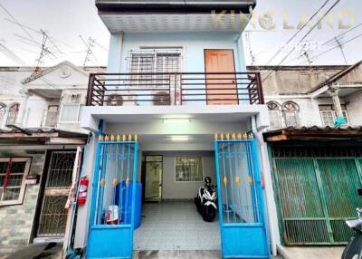 Front view of a two-story building with blue gates