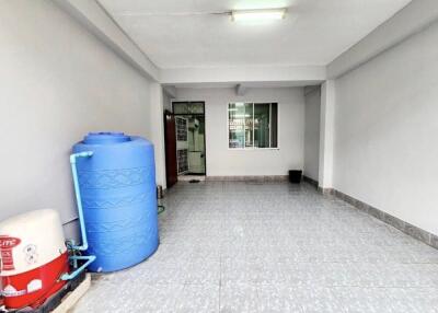 Spacious garage area with a water tank and tiled floor