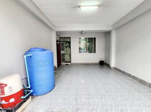 Spacious garage area with a water tank and tiled floor