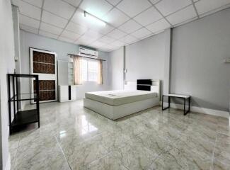 Spacious bedroom with tiled floor and modern furniture