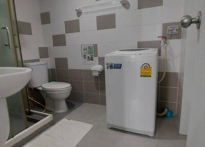 Modern bathroom with washing machine and shower