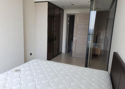 Modern bedroom with a large mattress and glass sliding doors