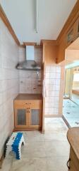 Compact kitchen with wooden cabinetry and tiles