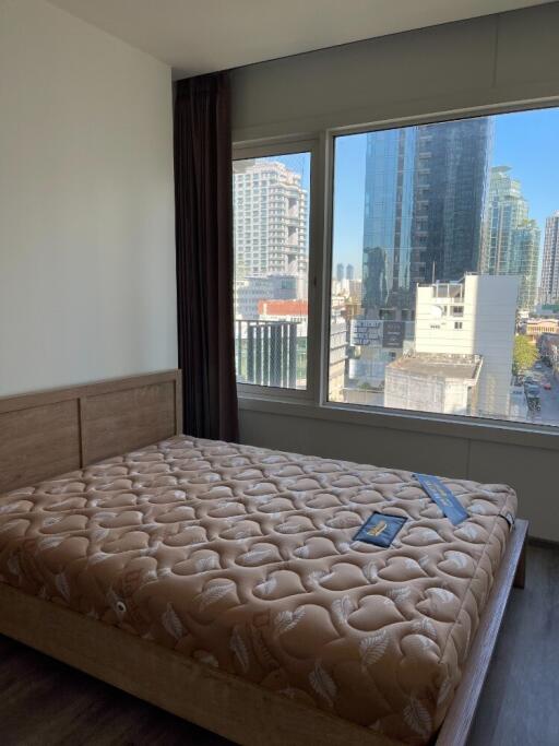 Bedroom with a window overlooking city buildings