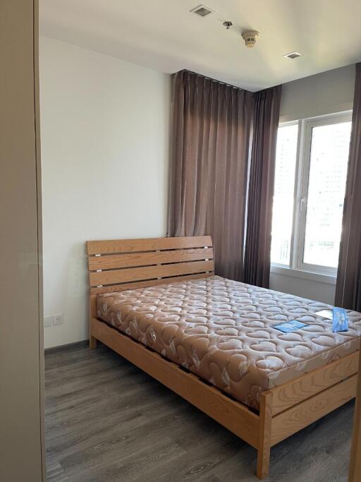 Modern bedroom with wooden bed and large windows