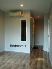 Bedroom 1 with wooden flooring and air conditioning