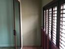 Balcony with sliding glass door and wooden shutters