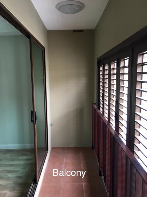 Balcony with sliding glass door and wooden shutters