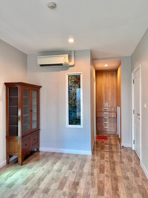 Small living area with wooden cabinet and an air conditioner