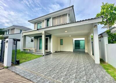 Front view of the house with driveway and lawn