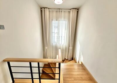 Bright staircase with wooden steps and modern railing