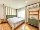 Modern bedroom with wooden flooring and green-themed decor