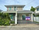 Front view of a house with for sale sign