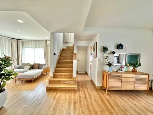 Spacious living room with wooden flooring and staircase