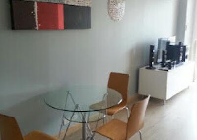 Modern dining area with glass table and wooden chairs