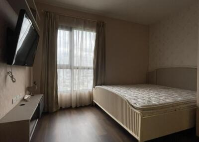 Bedroom with a large window and TV