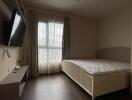 Bedroom with a large window and TV