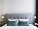 Modern bedroom with gray tufted headboard and green accent pillows