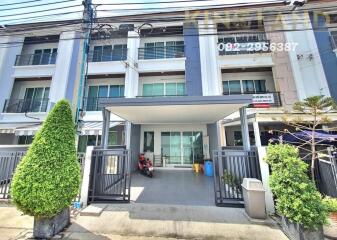 Front view of a multi-story residential building with a gated entrance