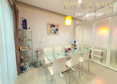 Modern dining room with glass table and six white chairs