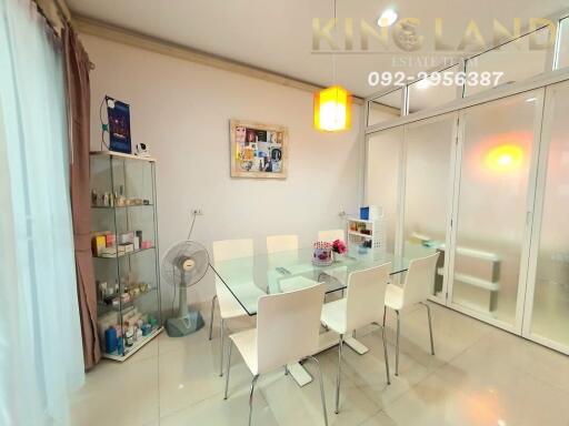 Modern dining room with glass table and six white chairs