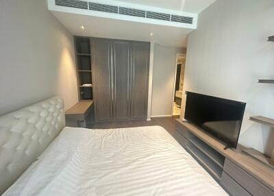 Modern bedroom with built-in wardrobe and TV