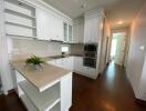 Modern kitchen with white cabinetry and built-in appliances