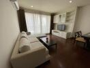 Living room with a white sectional sofa, coffee table, TV, and dining area