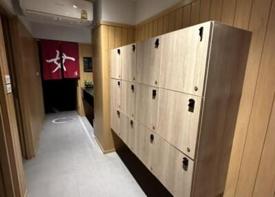 hallway with wooden lockers and wall-mounted air conditioning unit