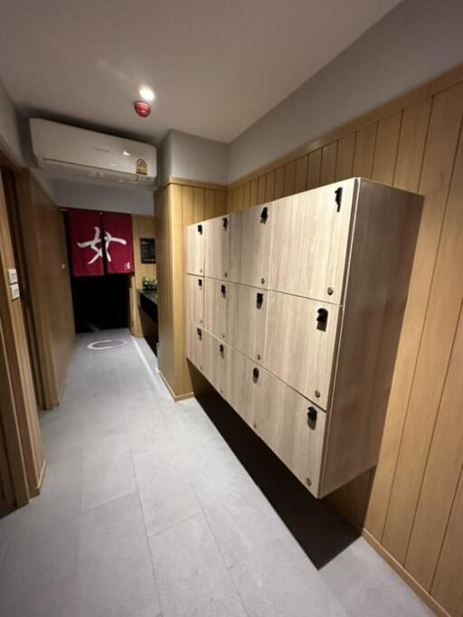 hallway with wooden lockers and wall-mounted air conditioning unit