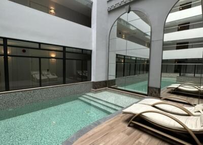 Indoor pool area with lounge chairs