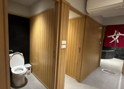 Modern bathroom view with toilet and wood-paneled walls