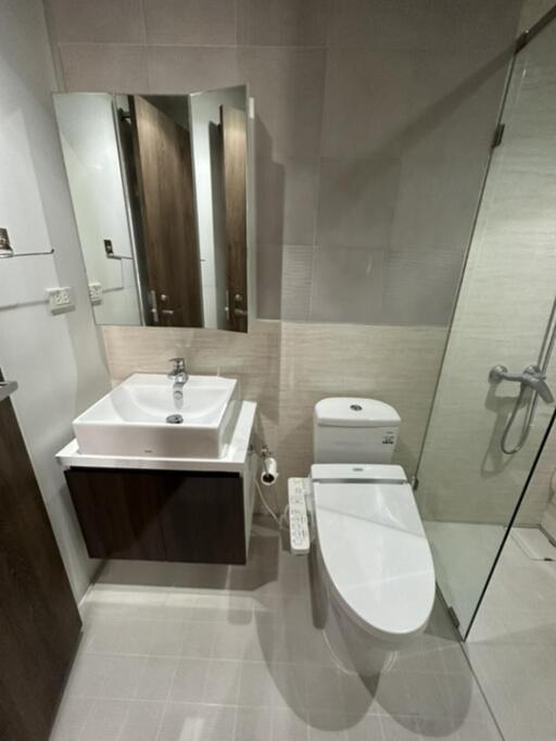 Modern bathroom with glass shower, vanity, and toilet