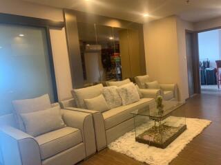 Modern living room with a glass coffee table and beige furniture