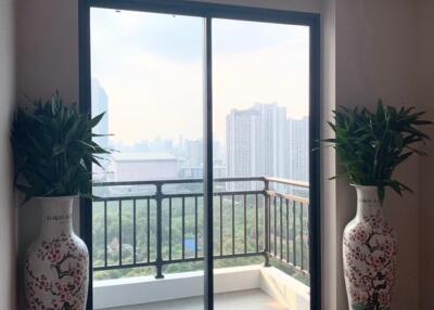 Living area with large sliding glass doors leading to a balcony with city view