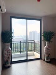 Living area with large sliding glass doors leading to a balcony with city view