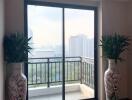 Living area with large sliding glass doors leading to a balcony with city view