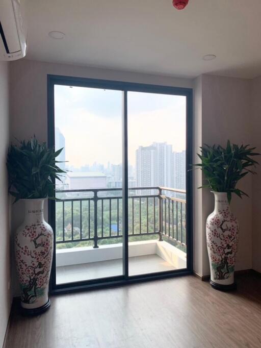 Living area with large sliding glass doors leading to a balcony with city view