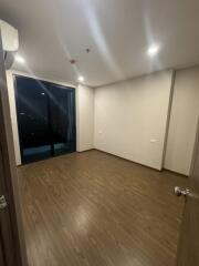 Empty bedroom with wooden flooring and balcony view