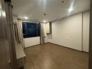 Empty bedroom with wooden floor and large window