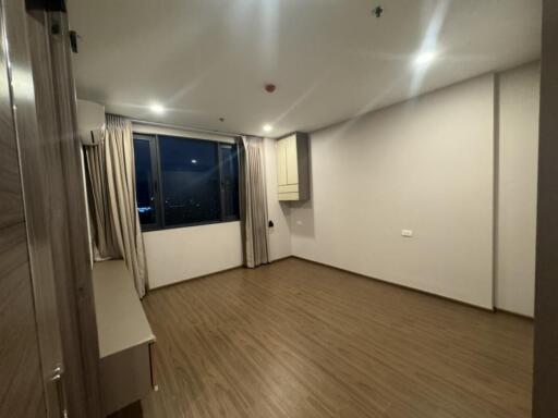 Empty bedroom with wooden floor and large window