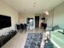 Modern living room with a TV, dining area, and balcony access